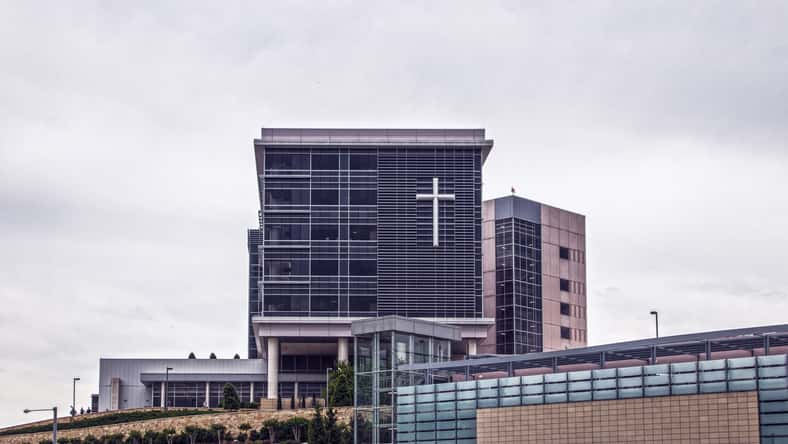 Hospital in Tulsa OKlahoma sitting up on a landscaped hill with giant cross on front windows