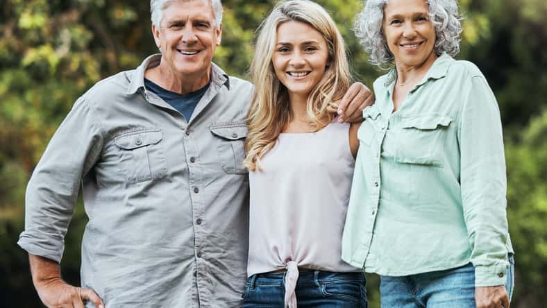 Portrait of mother, father and woman in park on hioliday in Australia together in summer. Happy, relax and love of parents for adult child on vacation in a green garden with family in nature.