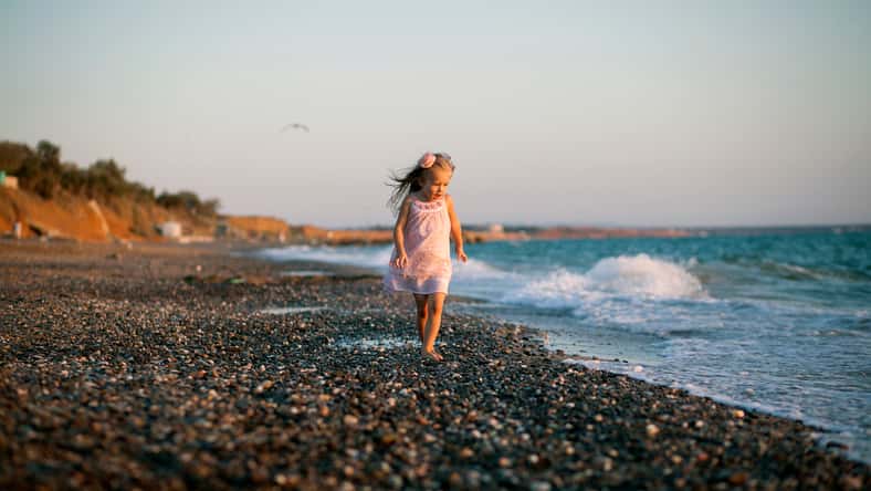 Silhouette of adorable little girl on a beach at sunset