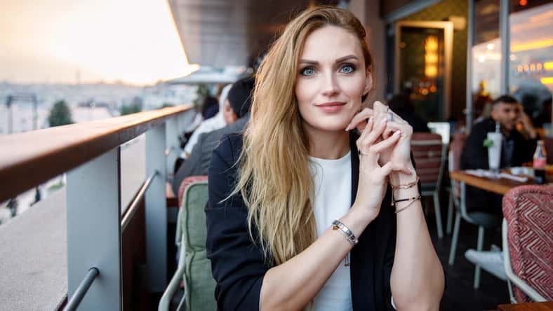 Young business woman drinking cappuccino and cup of coffee. Happy alone woman in outdoor cafe or restaurant on sunny summer day, break for lunch between meetings
