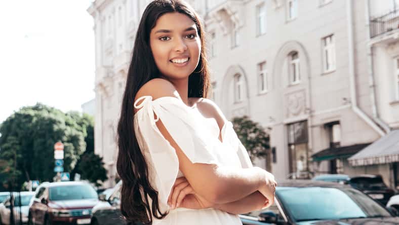 Young beautiful smiling hipster woman in white dress.