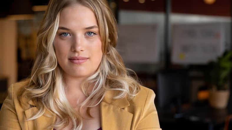 Portrait of happy plus size caucasian casual businesswoman with long blonde hair in office