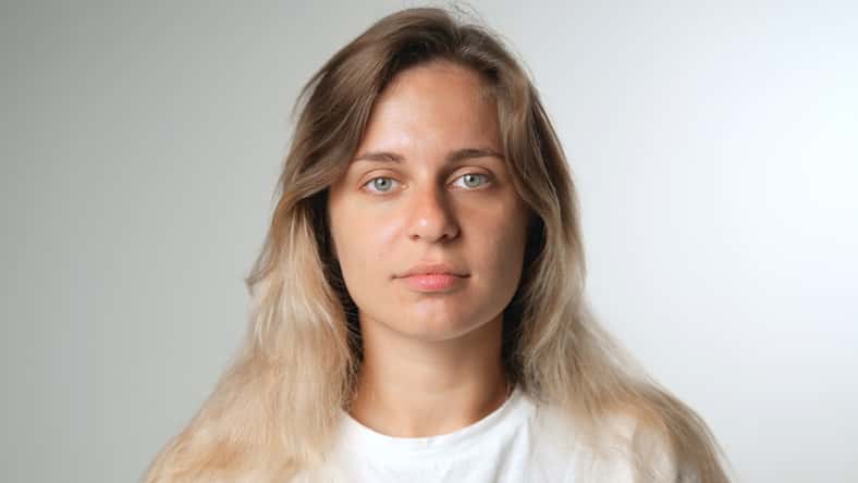 Beautiful person look at camera close up. Young adult woman face portrait. Stylish 30 years old girl on isolated white background. Attractive female feminism model. Modern millennial feminist people.