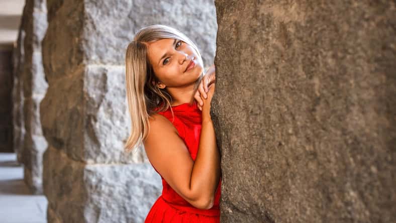 beautiful girl posing in a red evening dress in the park outdoors