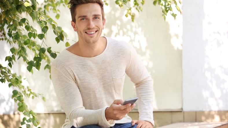 Young man talking on phone in the yard