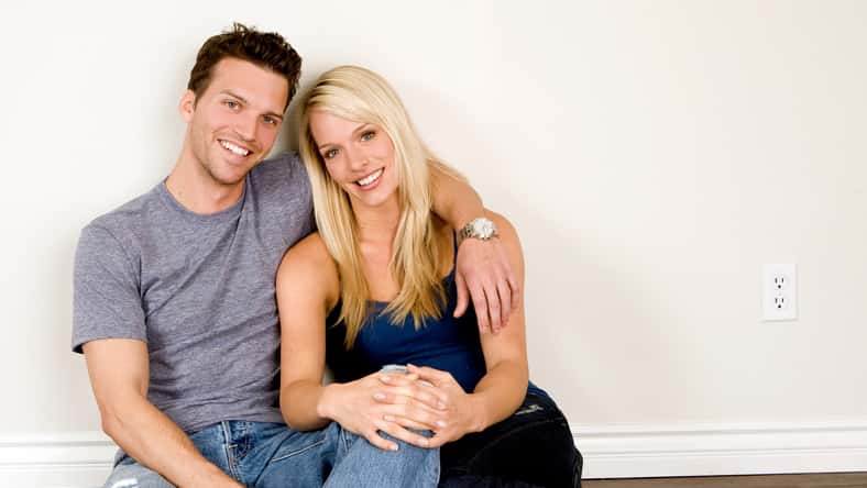 Attractive young couple sitting in their new home