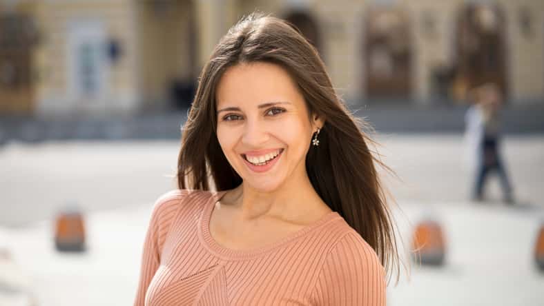 Closeup portrait of a happy young woman smiling, summer street outdoors