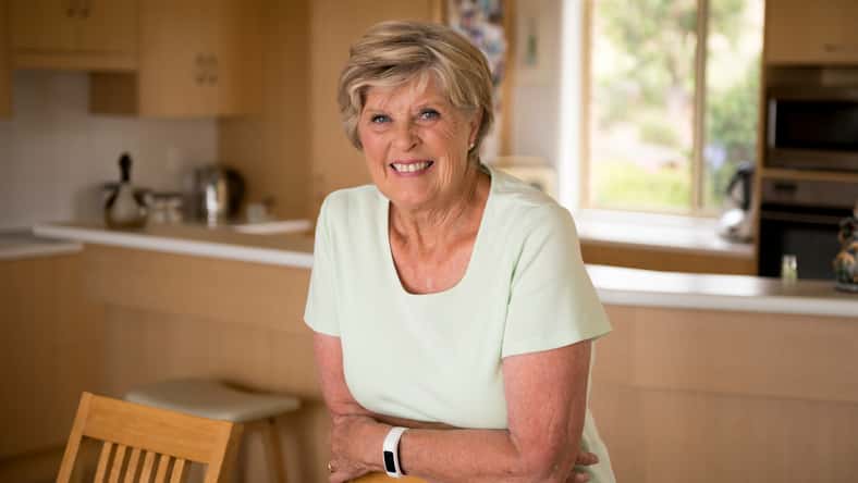 beautiful portrait of pretty and sweet senior mature woman in middle age around 70 years old smiling happy and friendly at home kitchen in aging and lifestyle concept,