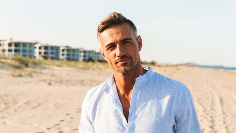 Portrait of a handsome man in shirt standing at the beach