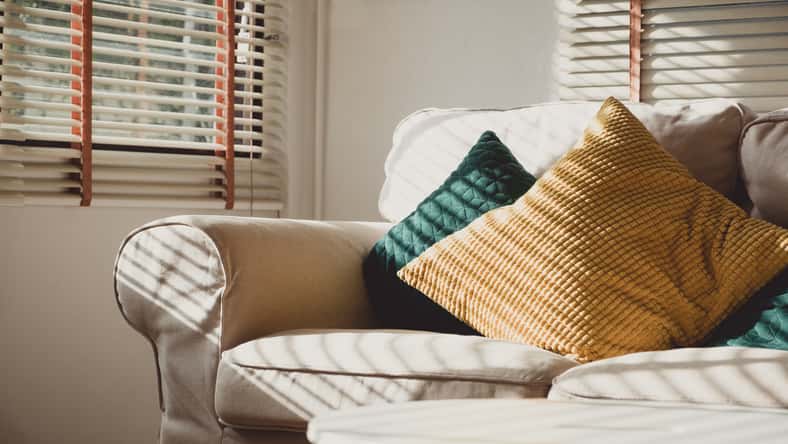 Close up pillow on sofa at home in morning with sunlight.Furniture in house background with light shade on object.