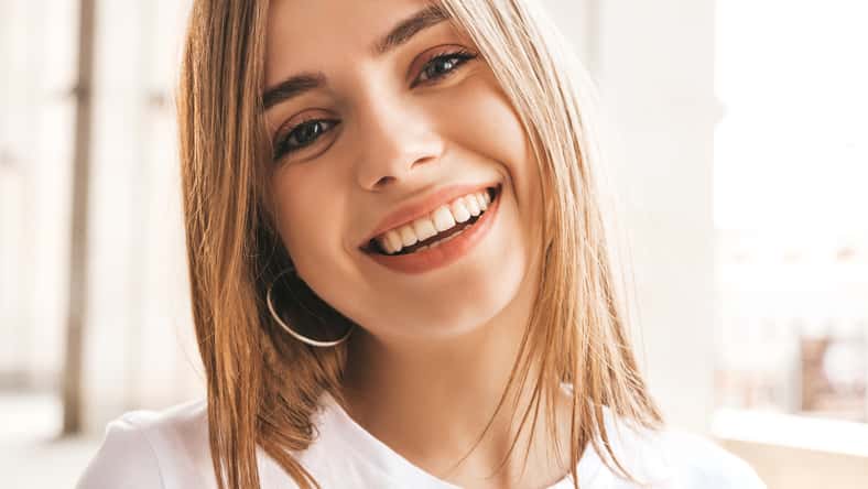 Portrait of beautiful smiling blond model dressed in summer hipster clothes. Trendy girl posing in the street background. Funny and positive woman having fun