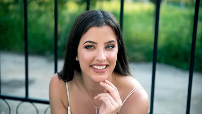 Young smiling woman sitting outdoors