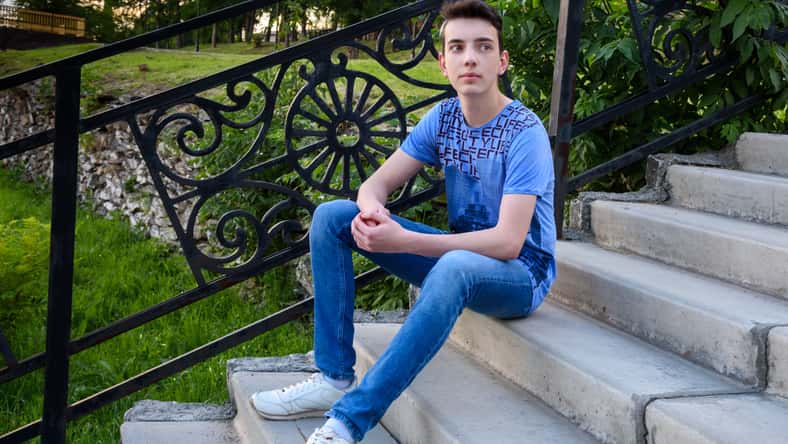 Teenage boy on the stairs on the street in summer