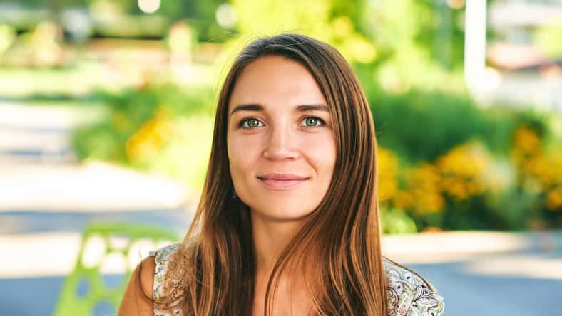 Outdoor close up portrait of beautiful woman resting in summer park