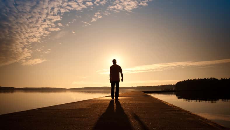 A man goes on the concrete pier in the sunrise
