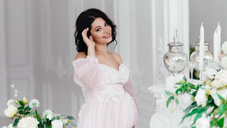 Beautiful pregnant girl in a dress in a bright room