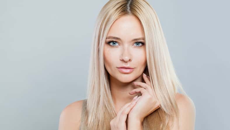 Natural beauty woman face close-up. Blonde model with fresh clear skin and healthy silky hair on white background