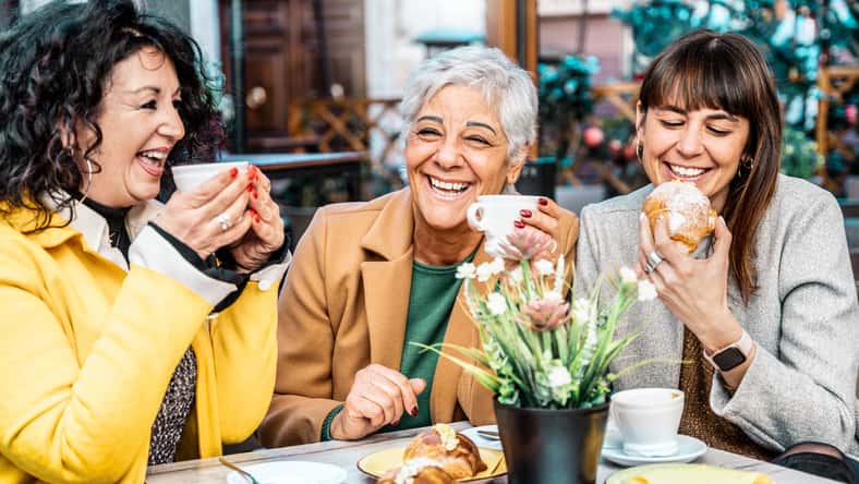 Group of happy older mature friends girls enjoying breakfast drinking coffee eat croissant at restaurant in city - Three senior women having fun at bar cafeteria - Joyful elderly lifestyle concept