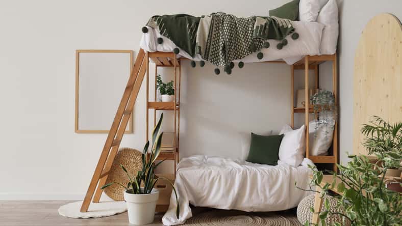 Interior of light children's room with bunk bed and plants