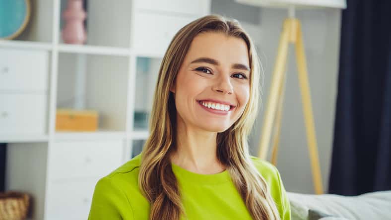 A young blonde-haired woman smiles in a
