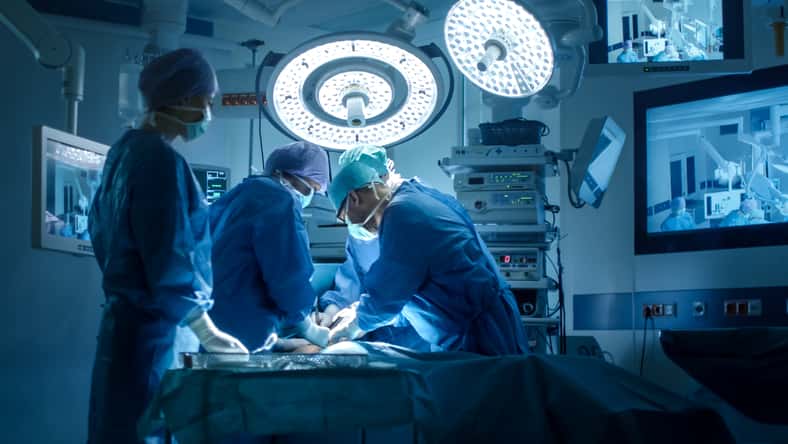 Equipo médico que realiza operación quirúrgica en la sala de operaciones moderna