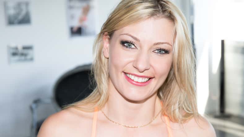 smiling fashion closeup portrait of young pretty woman blond in sport room