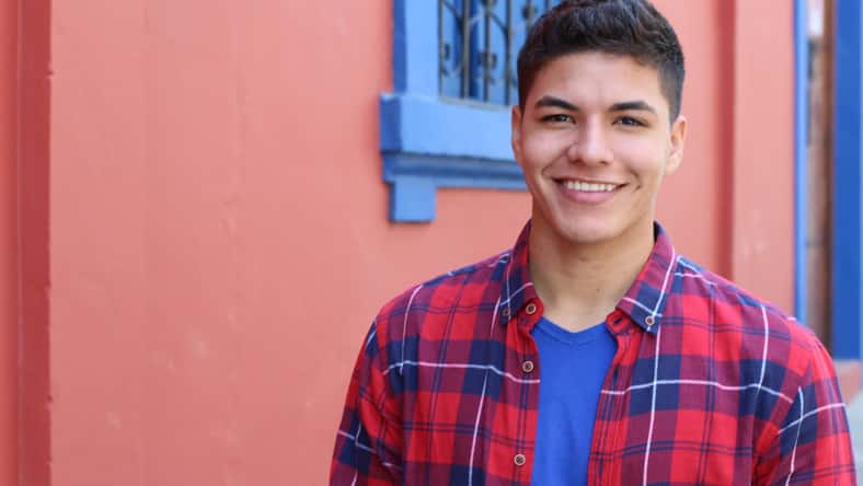 Handsome young hispanic male smiling outdoors