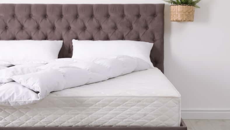Cama cómoda con colchón nuevo en la habitación. Sueño saludable