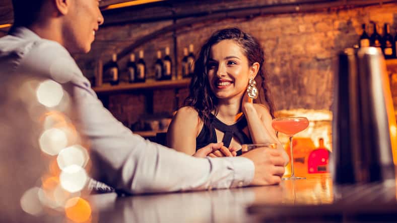 Girlfriend smiling. Beautiful girlfriend smiling while spending time with her loving man in bar