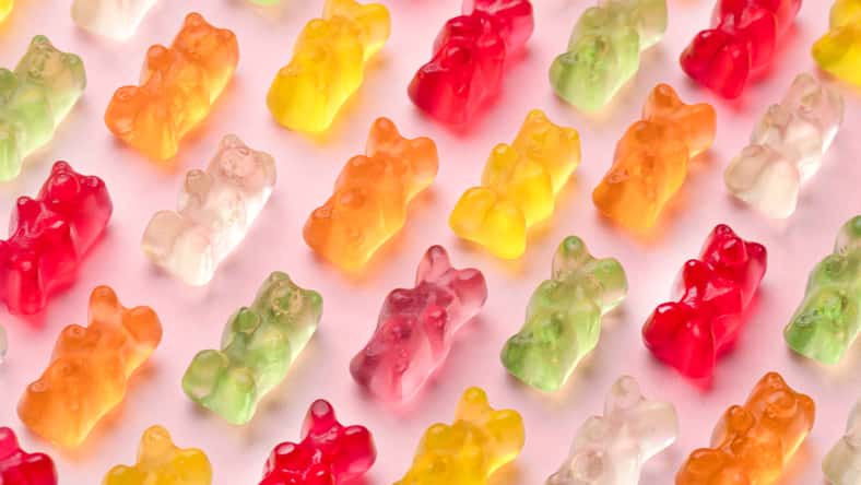 colorful gummy bears pattern over pink background, close-up image