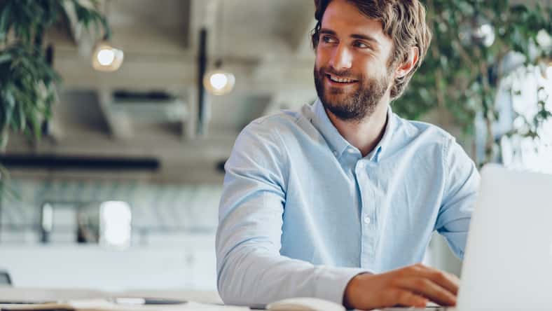 Businessman in shirt working on his laptop in an office. Open space office