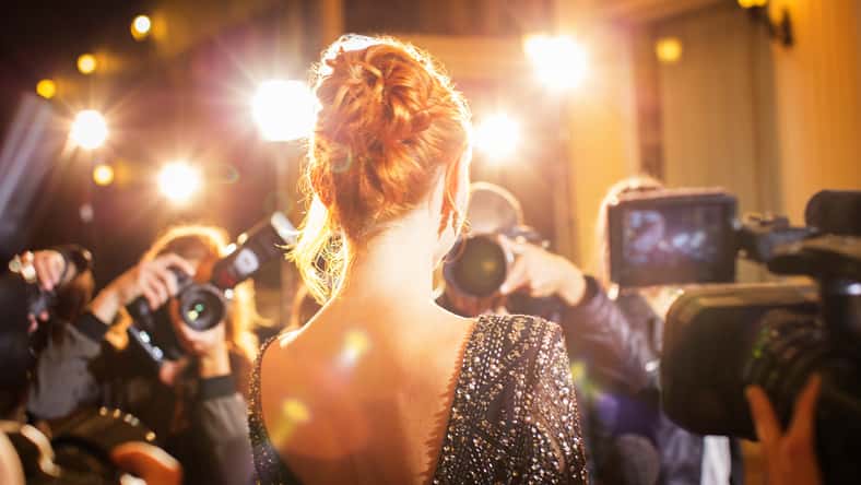 Celebrity being photographed by paparazzi photographers at event