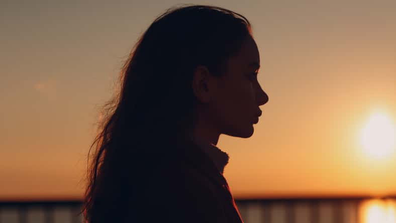 Young beautiful woman profile portrait at sunset