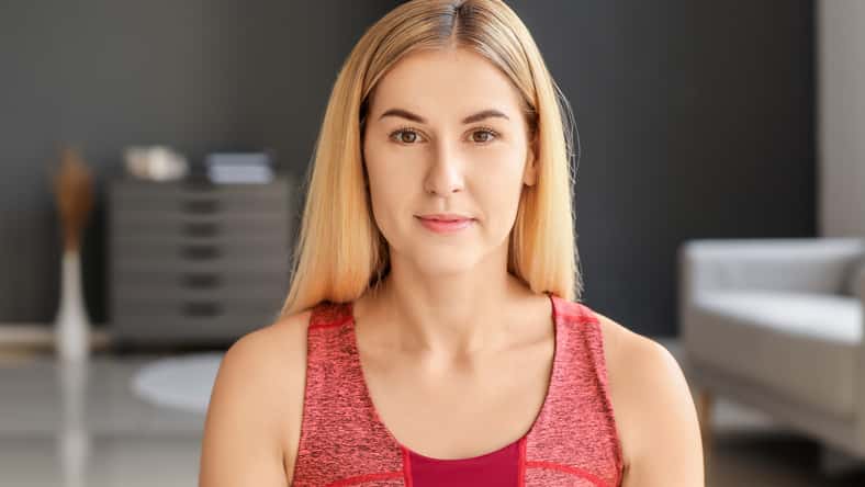 Sporty young woman training at home