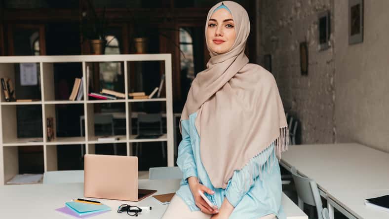 young pretty modern muslim woman in hijab working in office room, education online, remote work freelancer, fashion style