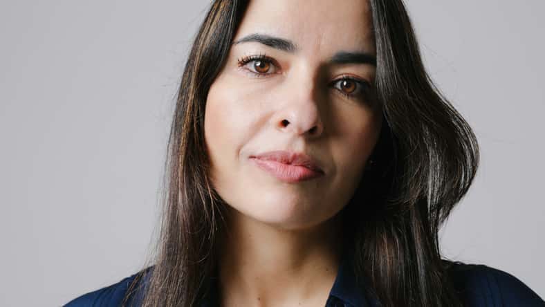 Middle-aged woman smiling friendly and looking in camera. Woman's face closeup. Realistic images with their own imperfections. Selective focus. High quality photo