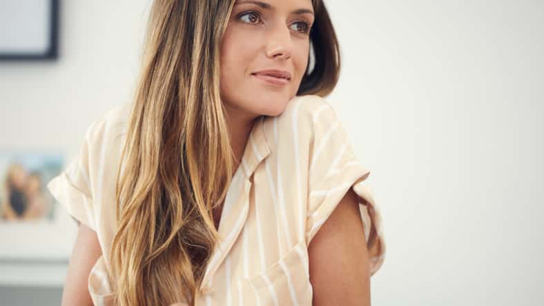 attractive woman looking thoughtful at home