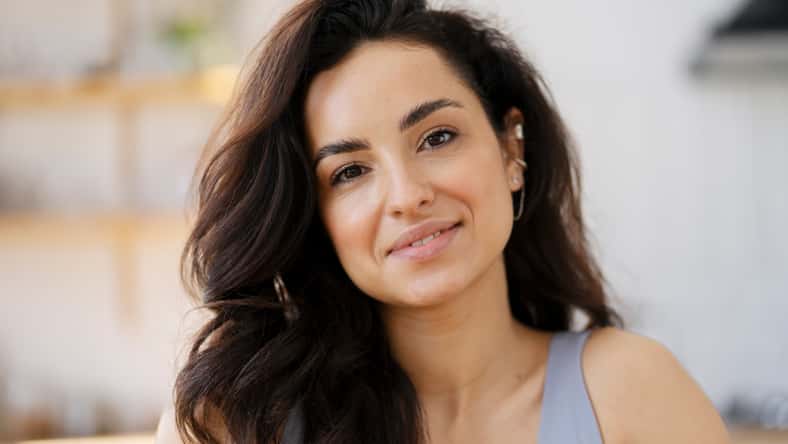 Closeup portrait of beautiful smiling latin woman looking at camera standing in kitchen. Positive emotions, healthy lifestyle concept