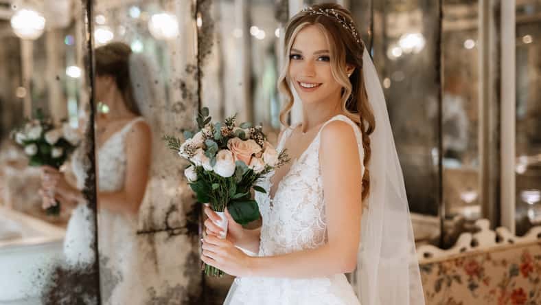 portrait of a bride in a white dress in a bright cafe with mirrors