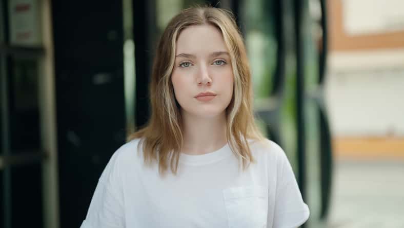 Young caucasian woman standing with serious expression at street
