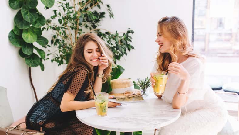 Cheerful girls in elegant dresses and trendy
