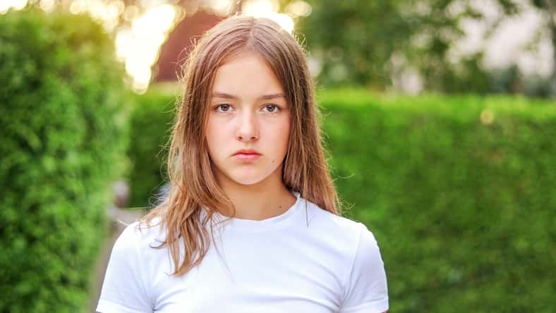 Close-up portrait of serious angry teenager girl