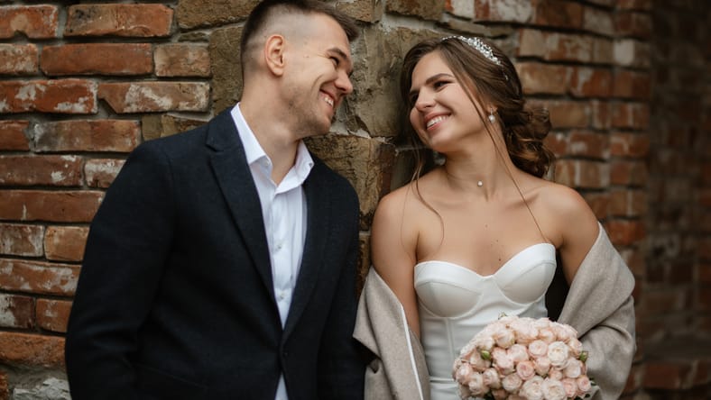 portrait of a young couple of bride and groom on their wedding day in a country cottage