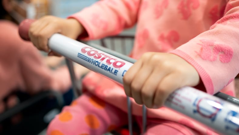 Un niño sentado en un carrito de compras de Costco