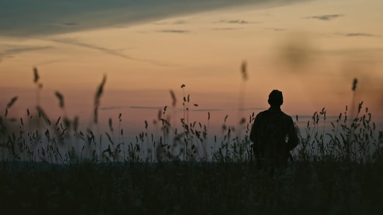 Silueta de soldado soviético anónimo caminando en el campo hacia el cielo del amanecer mientras lucha en la Segunda Guerra Mundial
