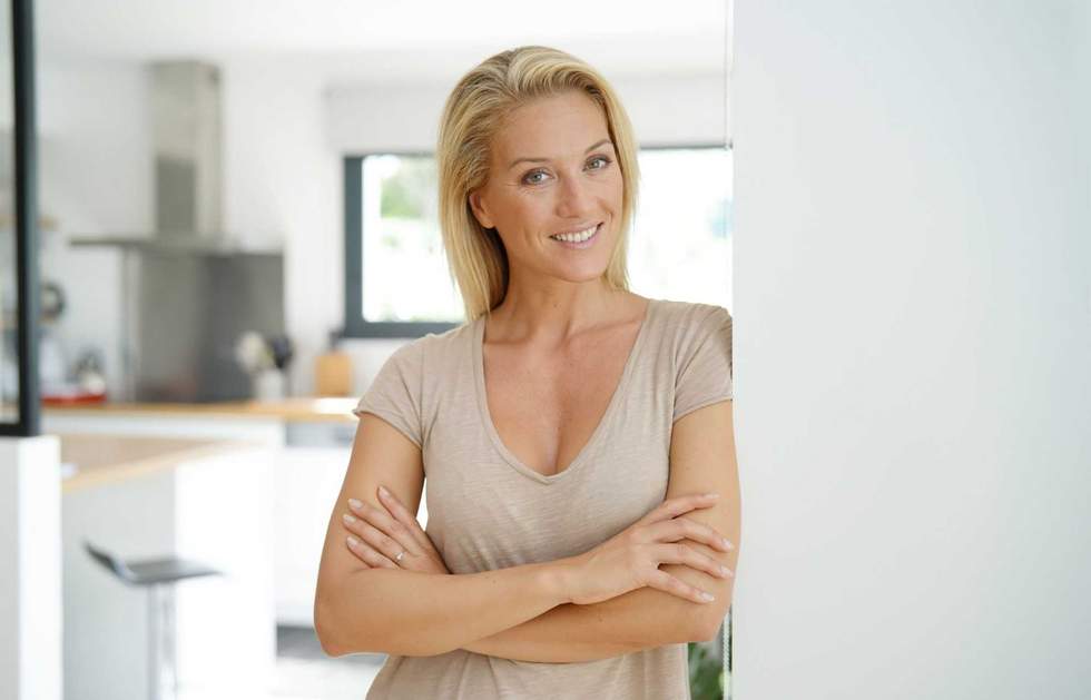 40-year-old blond woman standing inside house