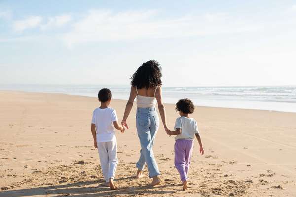 a mom holding the hands of her children