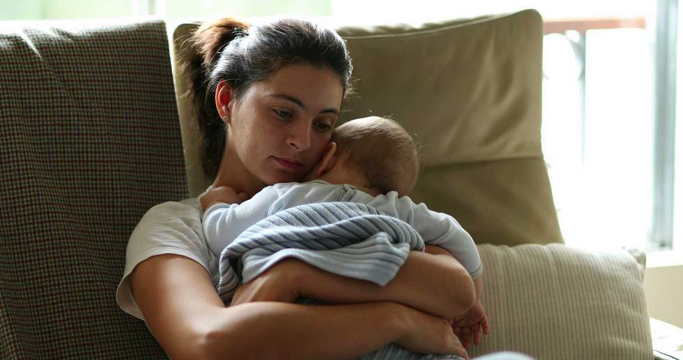 a tired mom holding a baby
