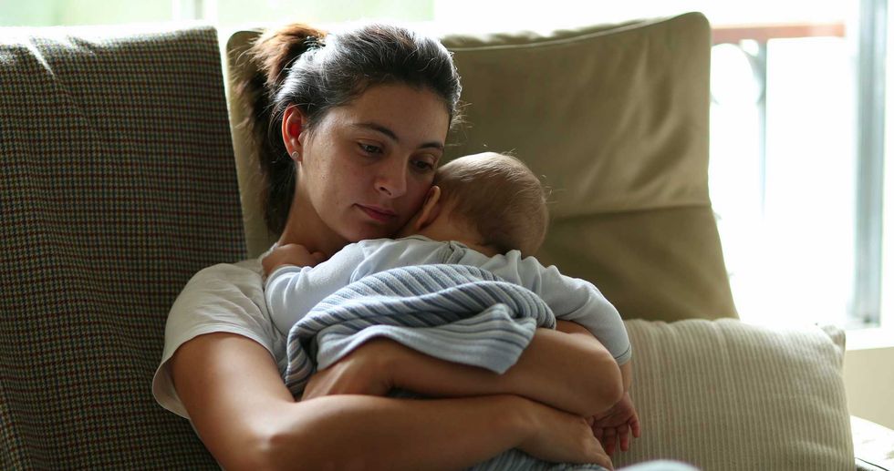 a tired mom holding a baby