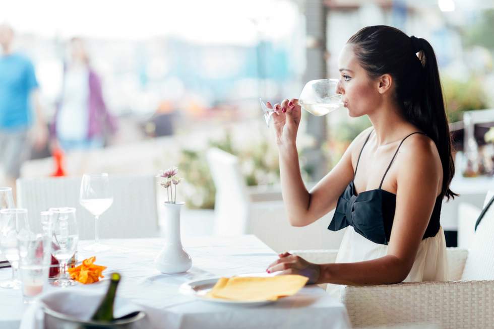 a woman drinking wine in a restaurant